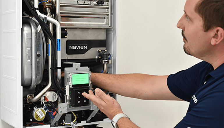 A gas engineer working on a Navien gas boiler, indicating training