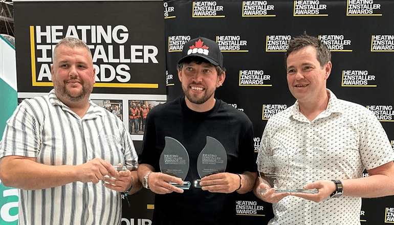2024’s National Heating Installer Awards top three: Daniel Davies (left), Damon Blakemore (centre) and winner Nick Irlam. All three are holding trophies and standing in front of an HIA banner