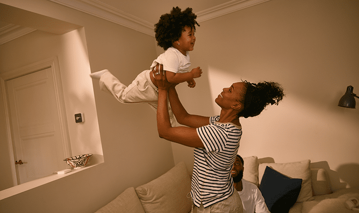 A young mother throwing her child in the air joyously